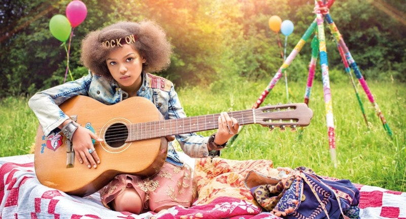 girl wearing headband playing guitar festival fashion shoot