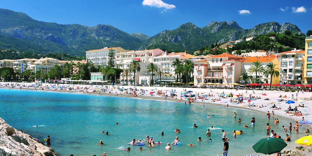 menton-beach-in-summer-retro-hotels-cote-dazur-mediterranean-mountain-backdrop-amira-el-fohail
