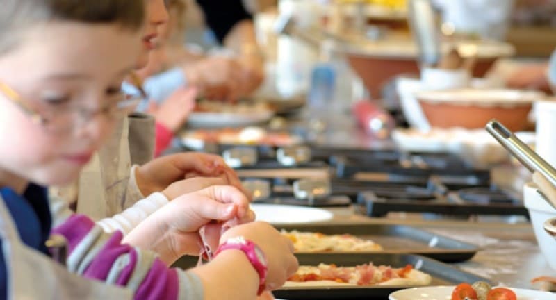 close up of kids making pizza
