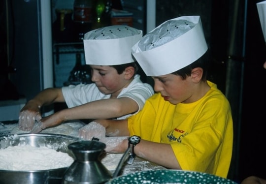 Children making pizza on a family holiday in Italy