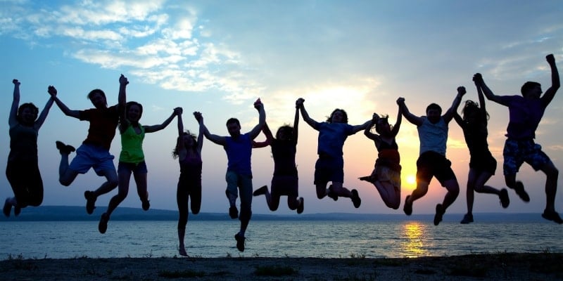 Teenagers jumping by the beach