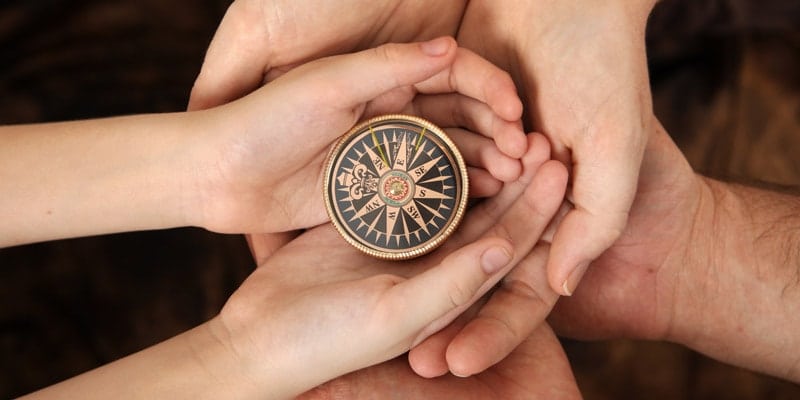 child-and-adult-hand-compass