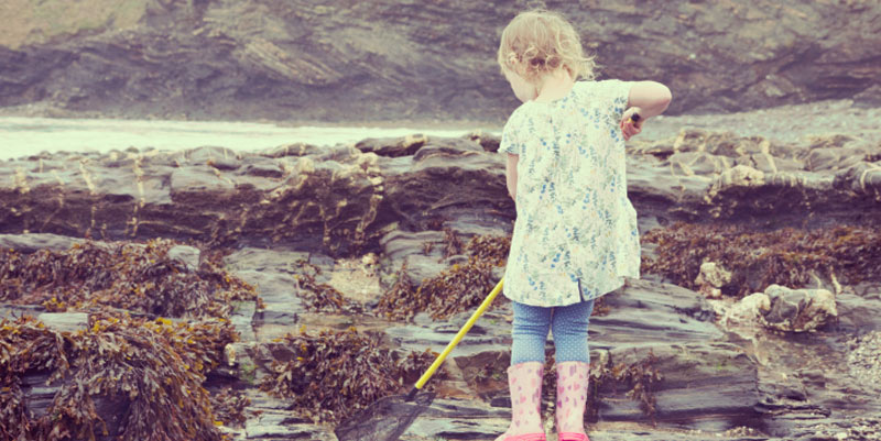 little-girl-fishing-in-rock-pools-on-beach
