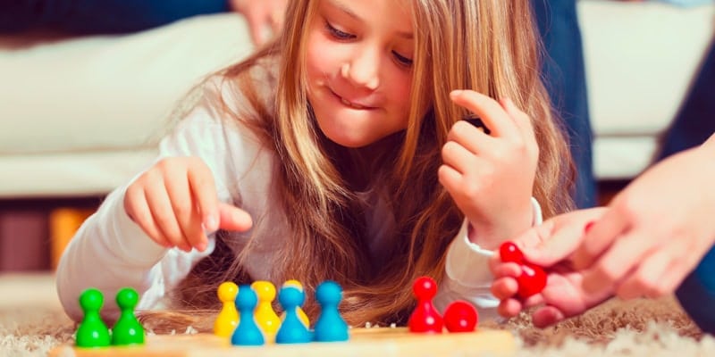 little-girl-playing-board-game-on-floor