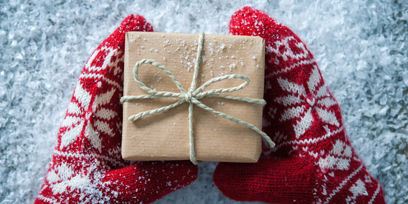 mittens-holding-present-in-the-snow