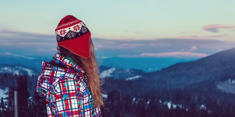 girl-in-winter-clothes-looks-out-over-mountains
