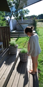 A young girl waters the herbs at Bluebells Cottage