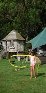 A girl swirling a ribbon infront of a treehouse at Dandelion Hideaway