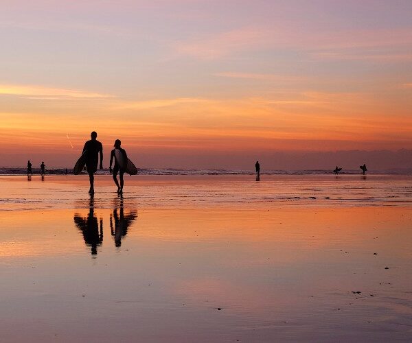 father-teenage-sun-walking-on-beach-with-surfboards-sunset-bali