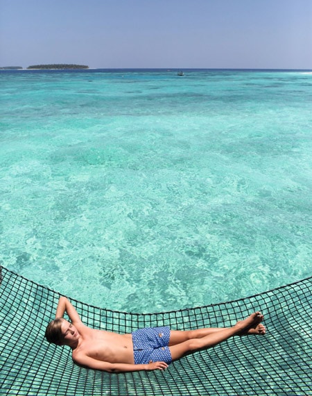 Boy laying by the sea Maldives 