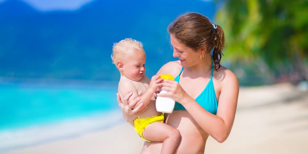 mother and baby on beach - tips for your first holiday with a baby