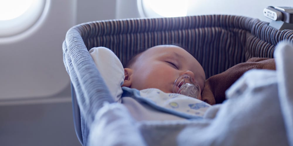 baby sleeping on plane - tips for your first holiday with a baby