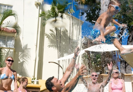 dad throwing boy in pool - Elegant Hotels