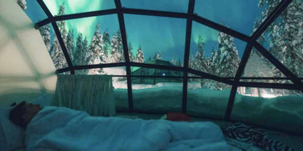 Man sleeping in Glass Igloo Village, Finland