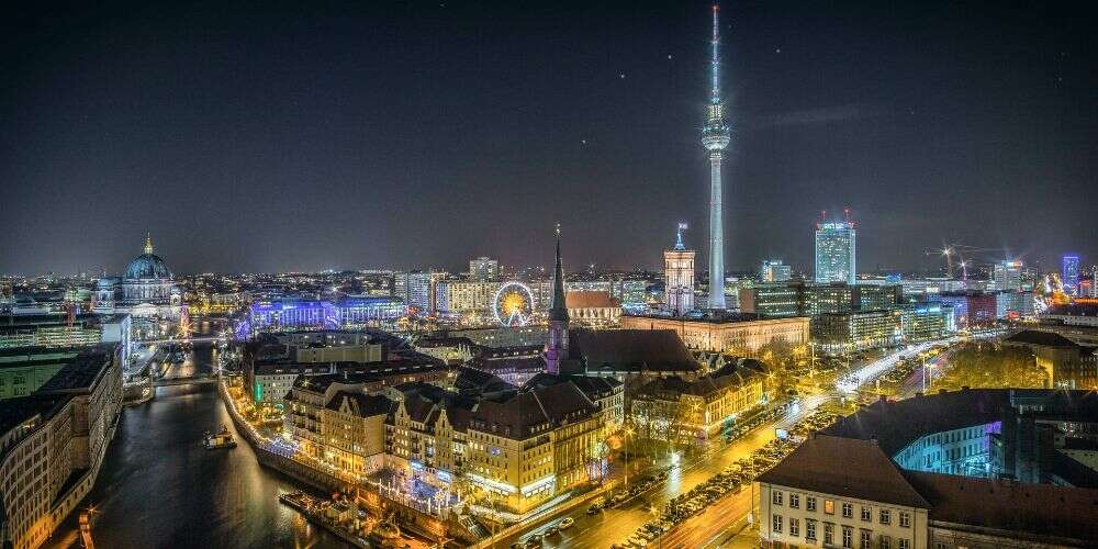 Berlin cityscape lit up at night in winter seen over Neukölln towards Mitte