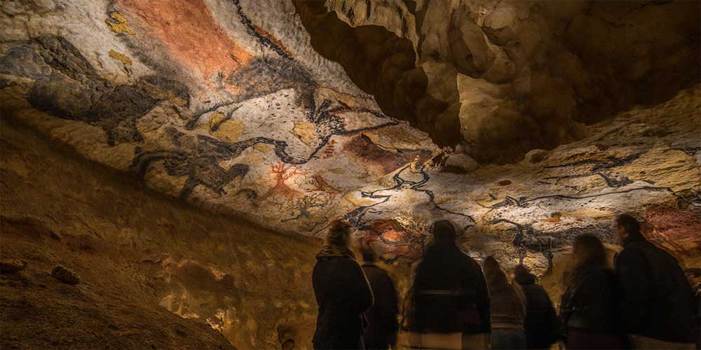 family-looking-at-prehistoric-lascaux-cave-paintings-family-traveller-guide-to-easter-in-dordogne-2022