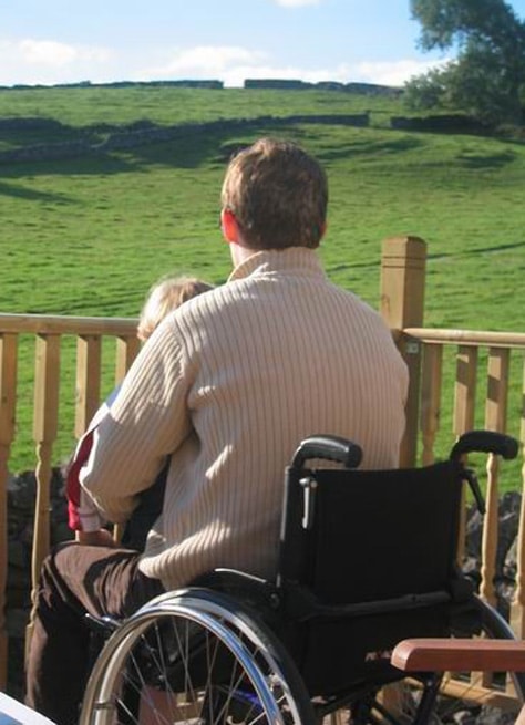 Man in wheelchair looking out over fields