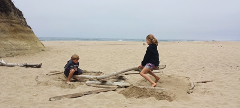 Two children play on seesaw on the beach