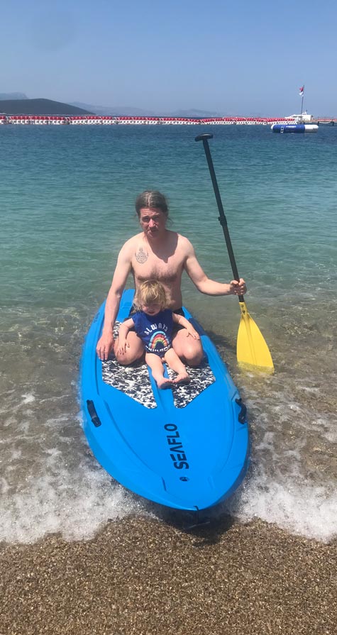 Beach holiday in Turkey, Rob Da Bank and son on paddleboard at Lux Bodrum, Turkey