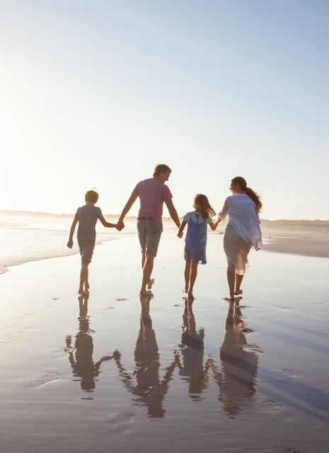 School holiday fines, family walking barefoot on the beach