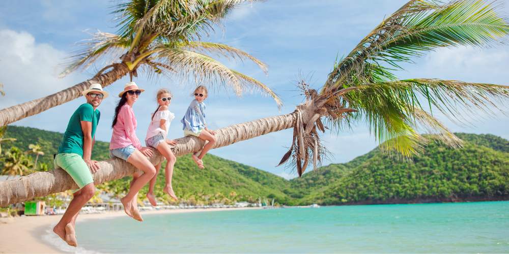 Best family holiday destinations 2019, family swing palm tree, Caribbean beach