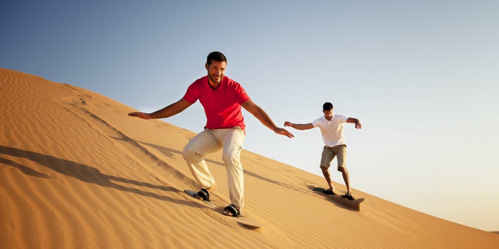 two-men-sandboarding-abu-dhabi-desert