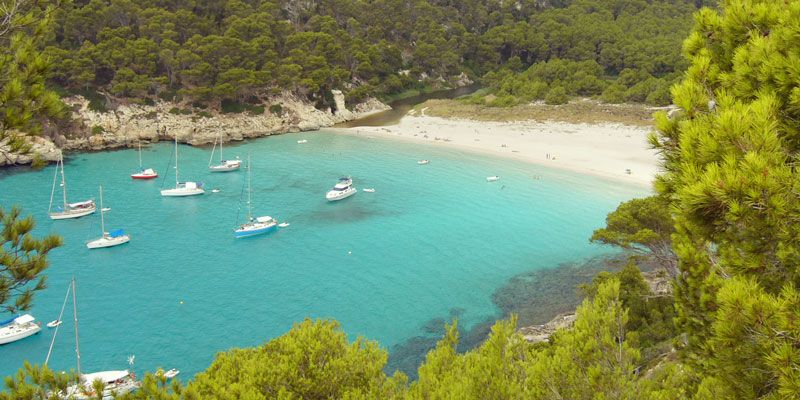 cala-trebalúger-menorca-sandy-cove-with-yachts-on-water-and-white-sand-beach