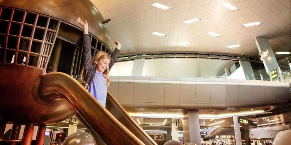 qatar-airways-special-fare-offers-young-girl-on-slide-hamad-international-airport