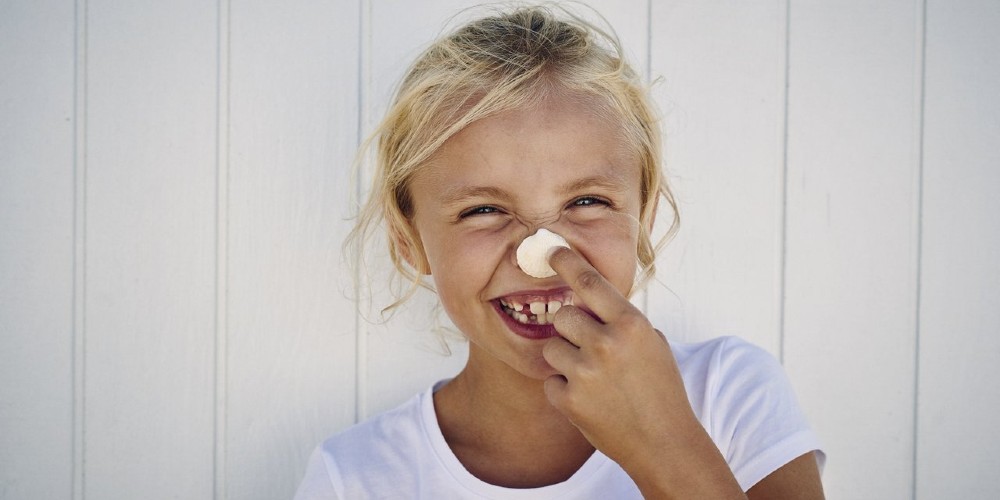 blonde-danish-girl-laughing-with-seashell-on-her-nose