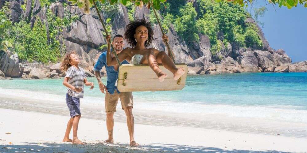 family on swing at Petite Anse Beach Mahe Seychelles family holidays 