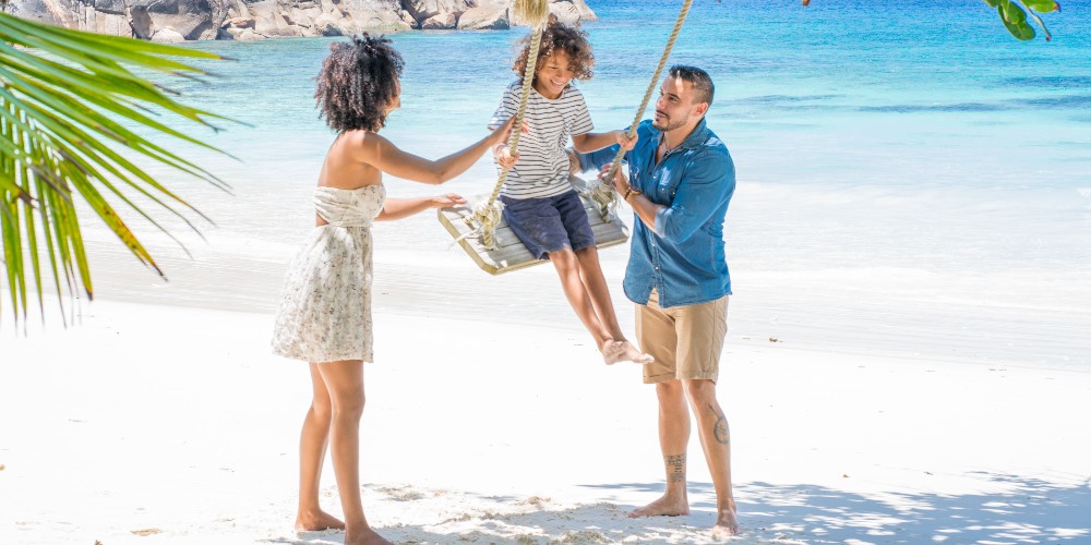 family-with-child-on-swing-indian-ocean-beach