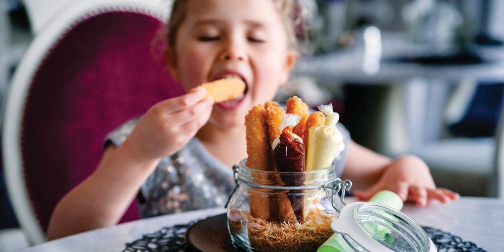 royal-caribbean-alice-in-wonderland-dining-kid-eating-crispymacncheesefries