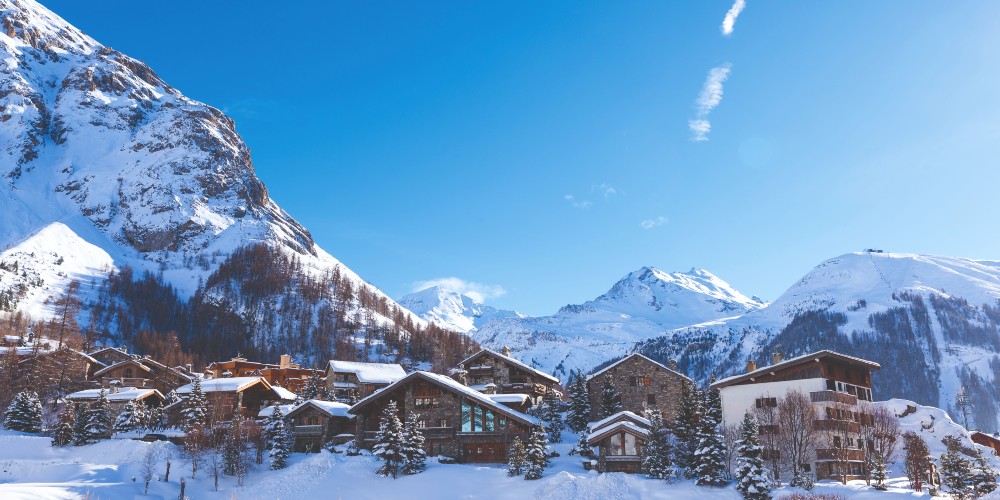 alpine-chalets-against-snowy-mountains-under-bright-blue-skies-val-disere-france