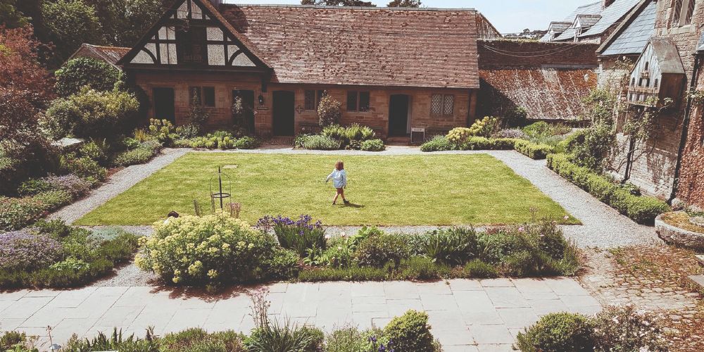 child-playing-in-welsh-manor-house-courtyard-garden-old-lands-estate-monmouth-wales-summer-sawdays