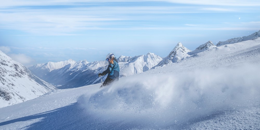 young-girl-downhill-skiing-under-cloudless-blue-sky-Paznaun-Galtür-Austria-winter-2022