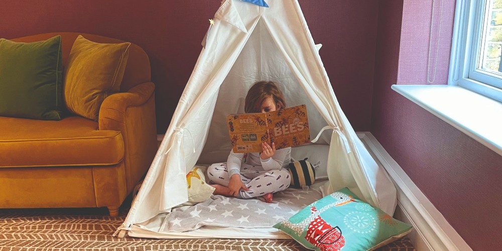 child-in-play-tent-wearing-pyjamas-st-ermine-hotel-london-family-traveller-2022