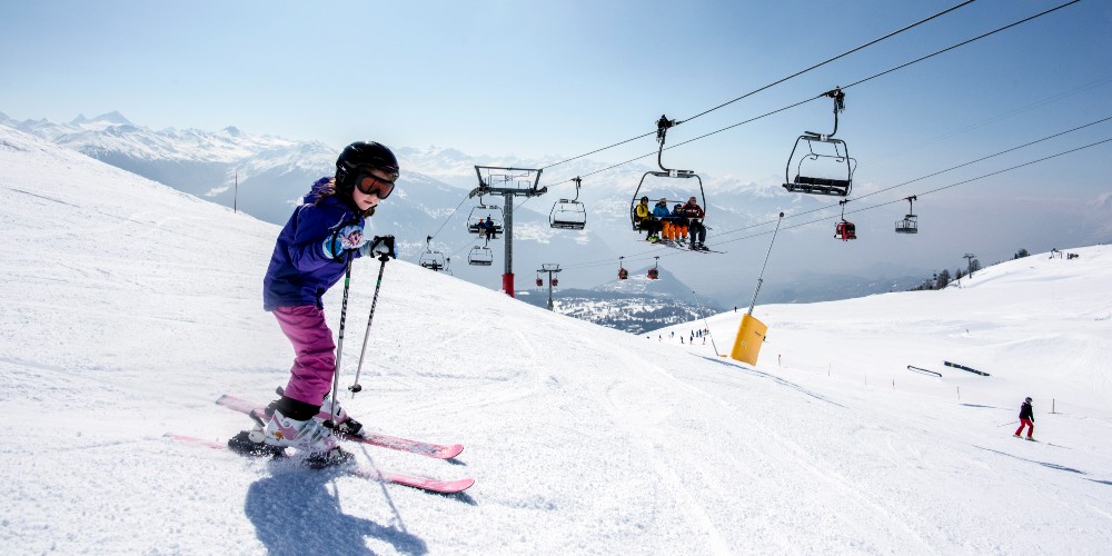 crans-montana-little-girl-skiing-under-gondolas-winter-holidays-swiss-resorts-@CMTC-PhotoGenic-OlivierMaire