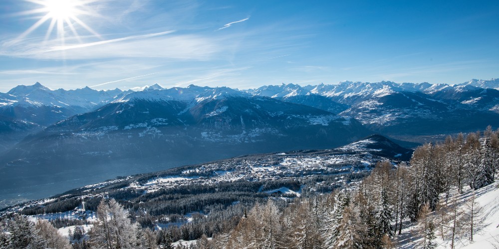 family-ski-breaks-in-switzerland-view-of-snow-covered-crans-montana-resort-in-valley-CMTC-Olivier-Maire