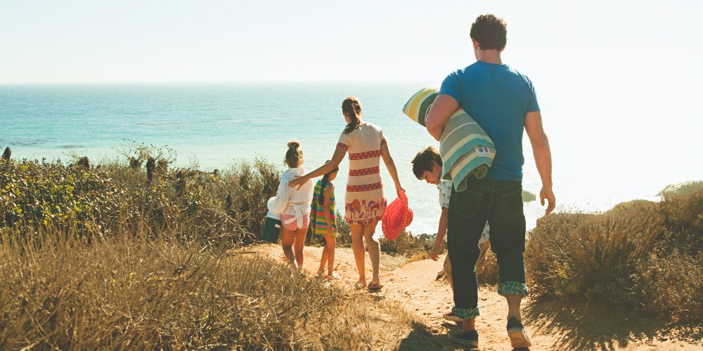 family-walking-to-amelia-island-atlantic-beach-florida-sunny-day-blue-skies-sea-view
