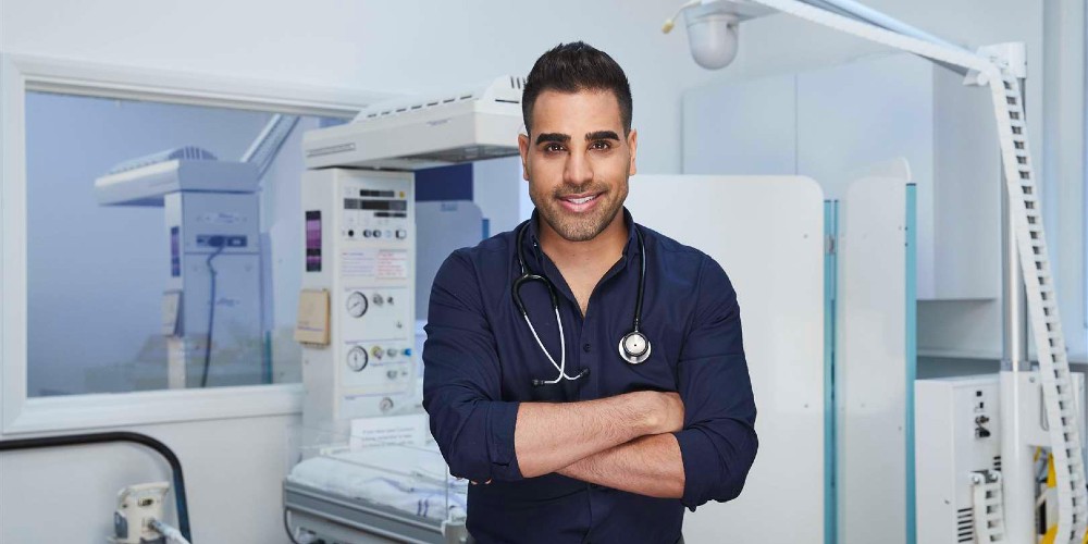 image-of-dr-ranj-singh-in-blue-shirt-with-stethescope-in-clinic-talking-family-health-advice-family-traveller-2022
