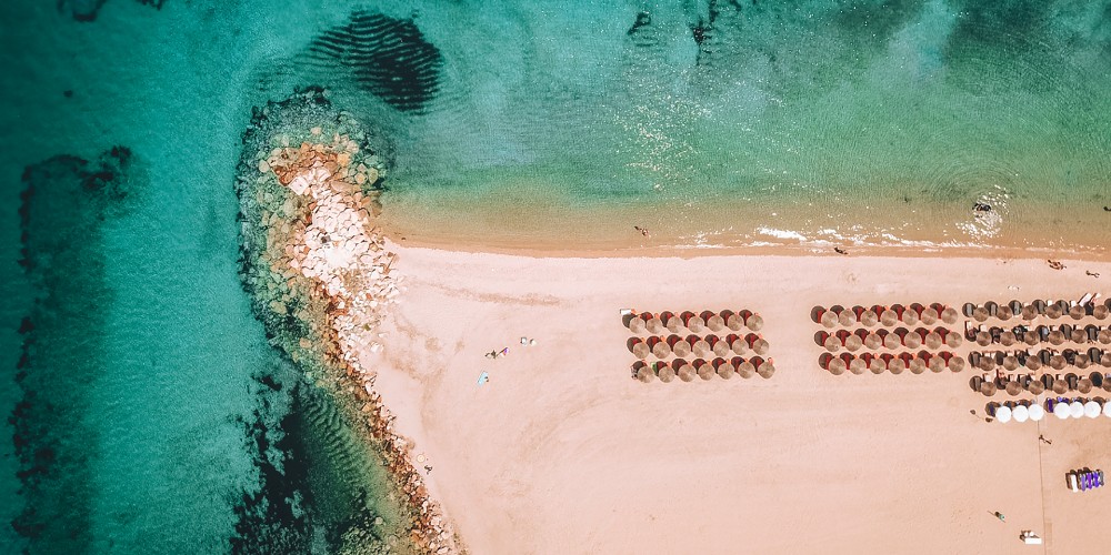 drone-shot-of-golden-sands-and-sun-umbrellas-on-nea-potidea-beach-kassandra-guide-to-greece-summer-2022