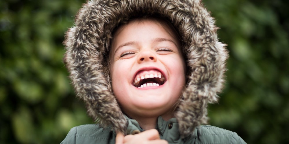 little-boy-in-fur-trimmed-hood-laughing-dr-ranj-family-health-advice-for-parents-2022-s-b-vonlanthen 