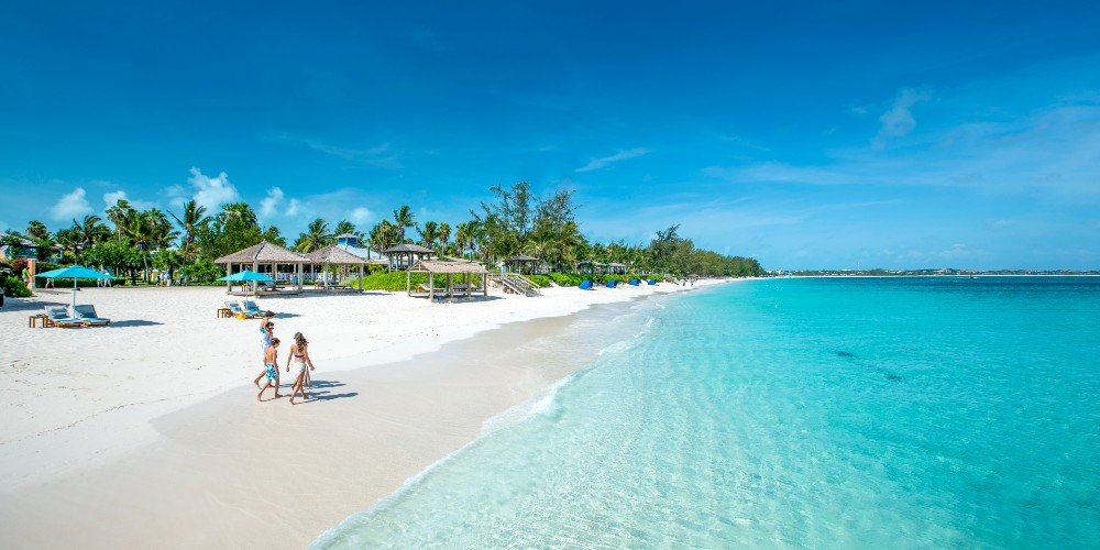 beaches-resorts-turks-and-caicos-family-walking-on-grace-bay-beach-2022