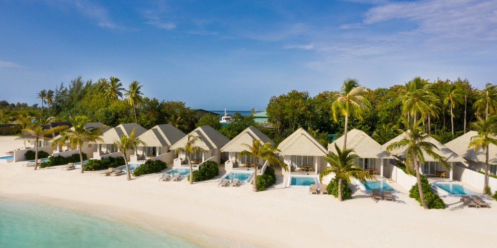 sun-siyam-olhuveli-beach-suites-with-pools-and-palm-trees-in-background-luxury-indian-ocean-breaks-for-families