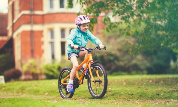 young-girl-riding-frog-bike-in-grounds-of-stately-home-england-family-traveller-2022