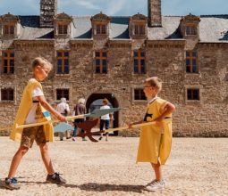 kids-dressed-as-knights-play-fighting-in-front-of-rocher-portail-castle-brittany-2022