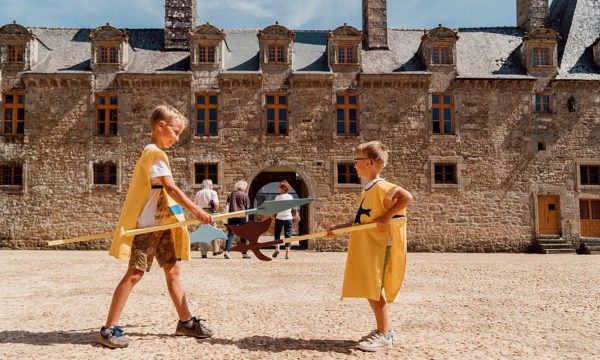 kids-dressed-as-knights-play-fighting-in-front-of-rocher-portail-castle-brittany-2022