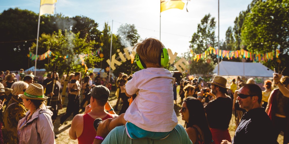 toddler-green-ear-defenders-on-dads-shoulders-isle-of-wight-festival-2022-james-bridle-festival-photography