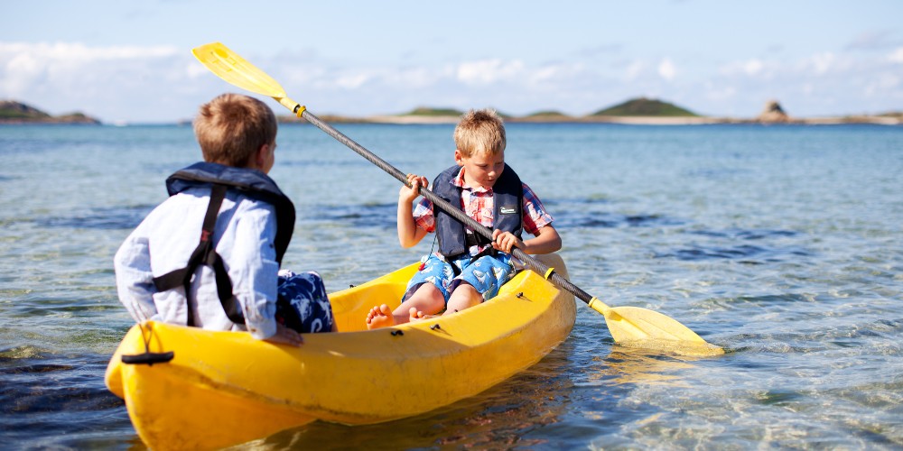 young-boys-paddling-kayak-on-st-agnes-island-isles-of-scilly-breaks-family-traveller-2022