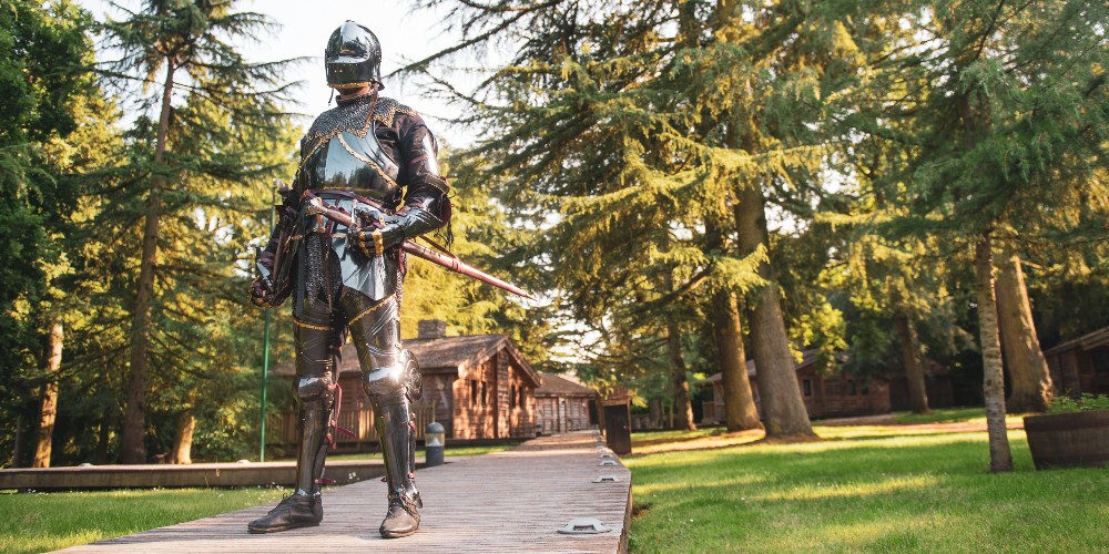 knight-in-medieval-armour-knights-village-with-family-lodges-warwick-castle-summer-2022